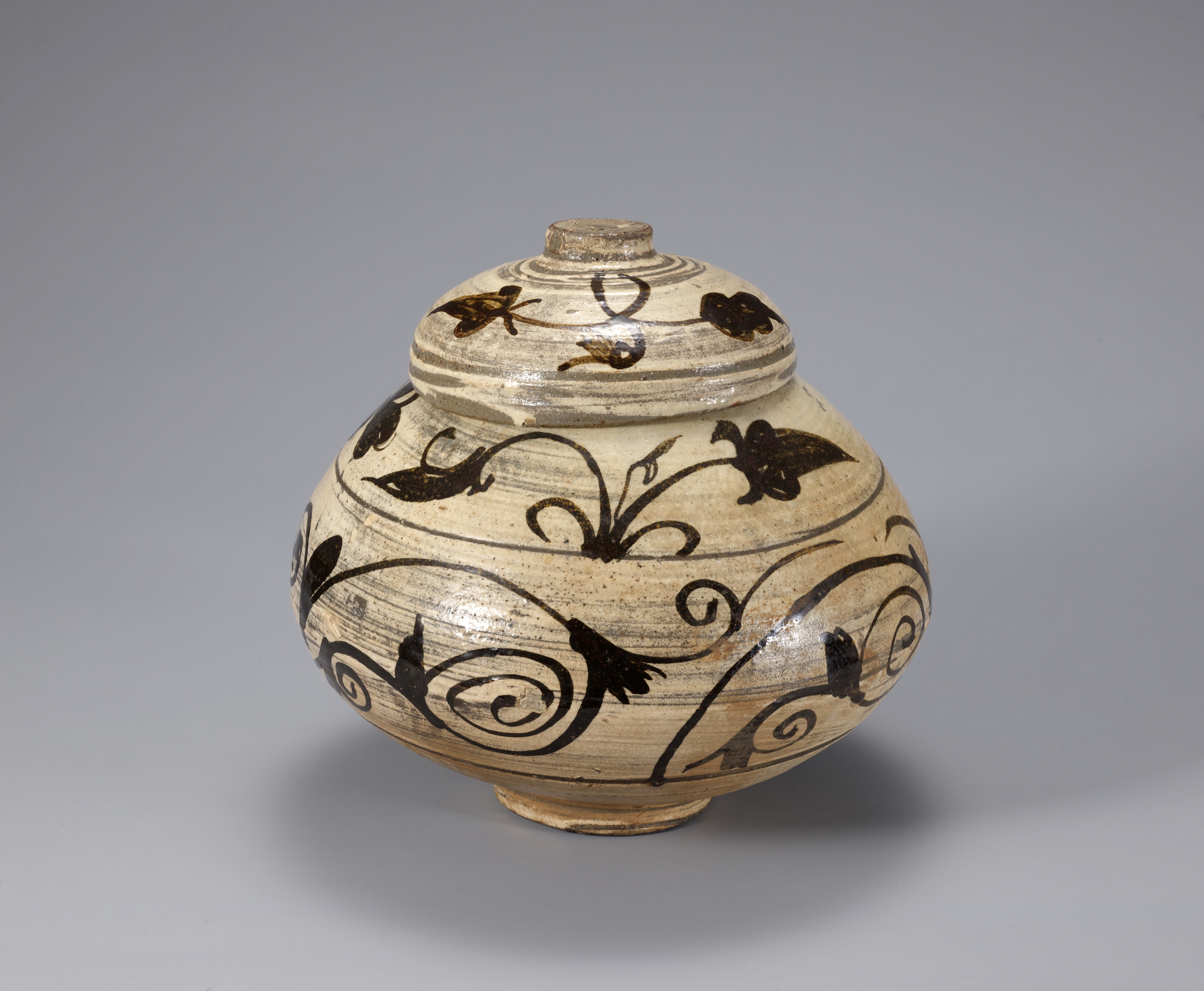 Lidded round buncheong jar painted with dark plant motifs